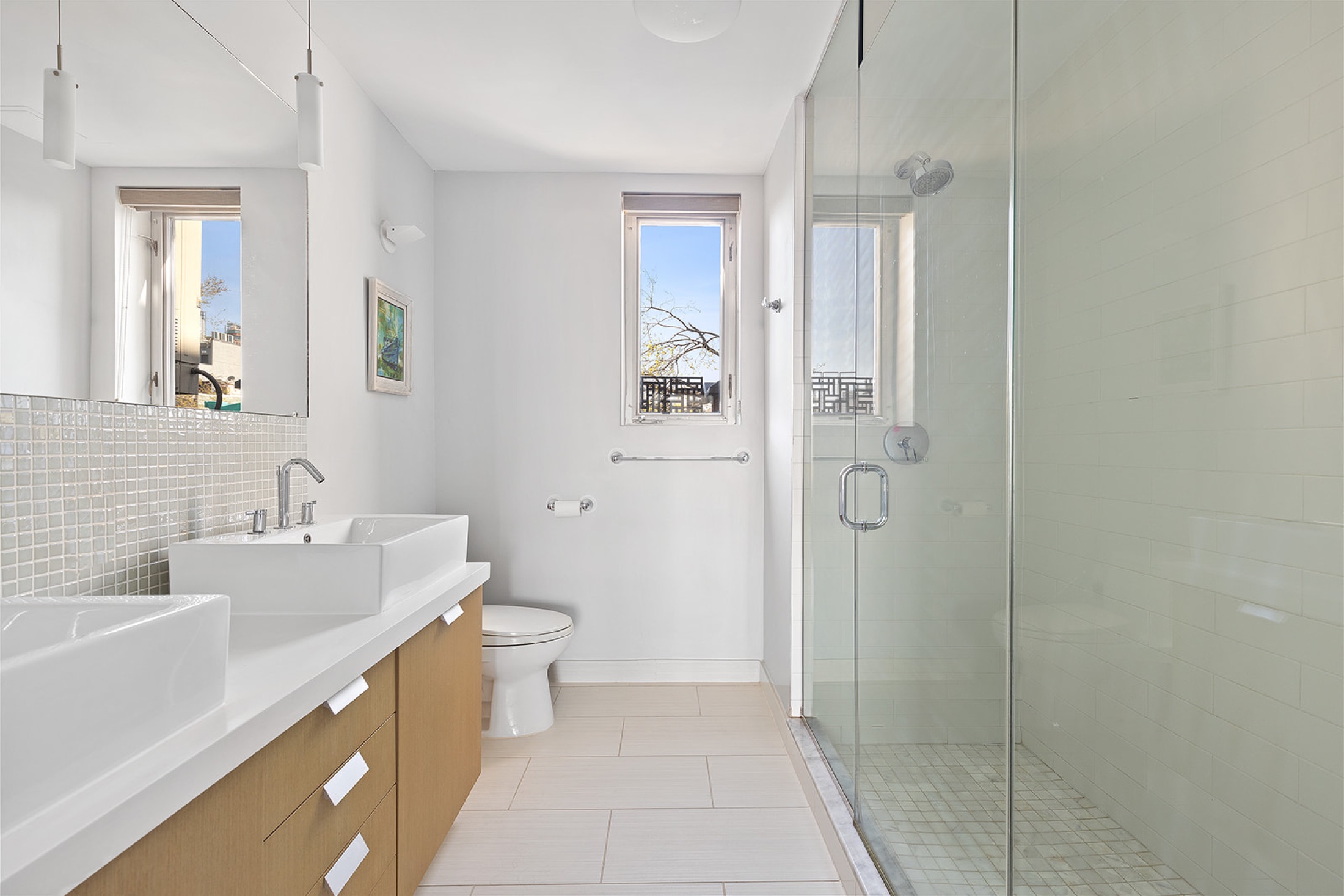 Windowed bathroom in Casa Vizcaya residence 3E with a glass shower and double vanity