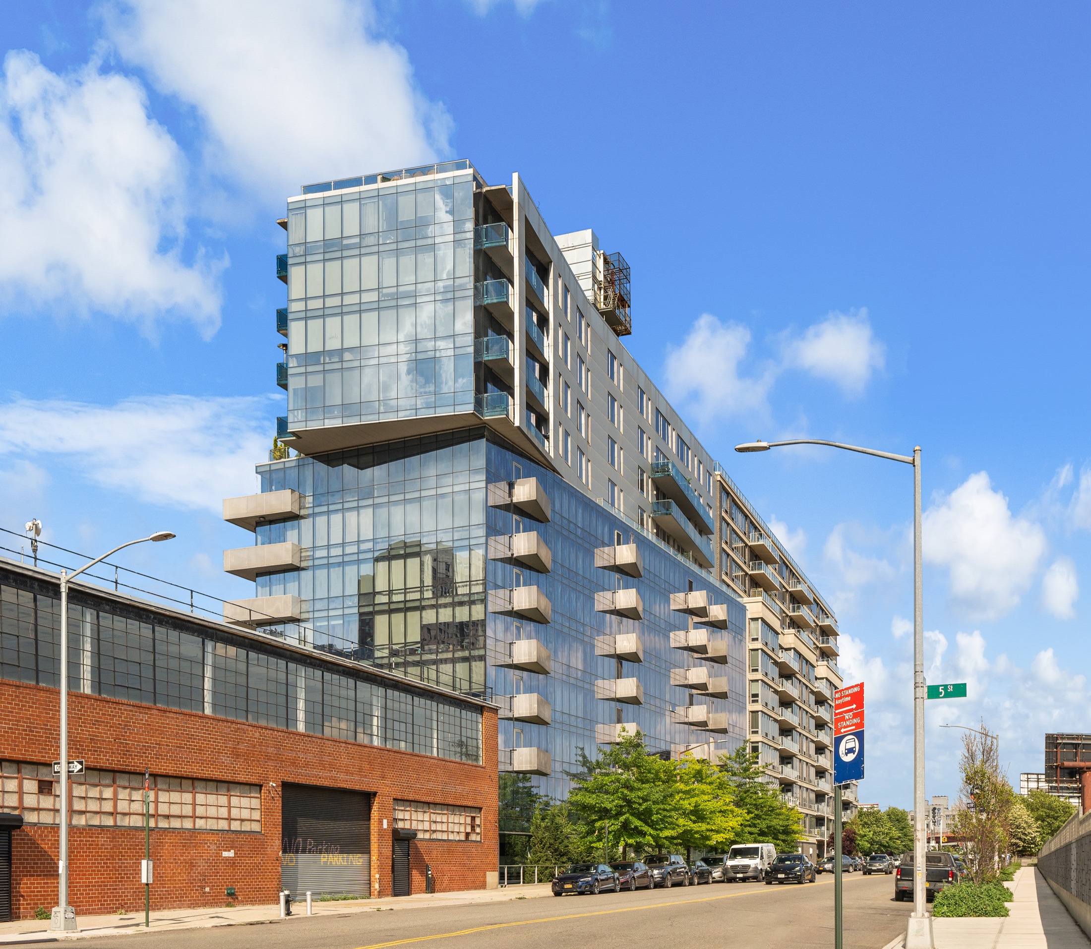 Street view of the Murano condominium glass facade and projecting balconies